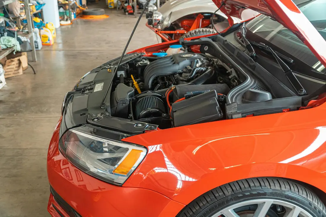 Close-up of a car engine bay being serviced at Apex Auto Works