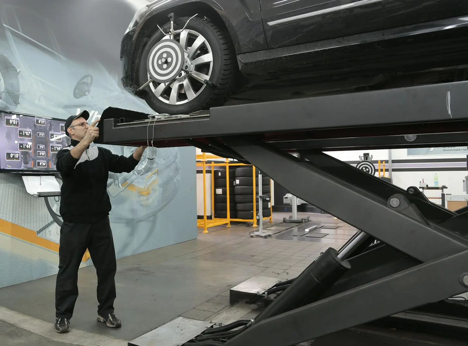 A technician inspecting a vehicle raised on a lift at Apex Auto Works