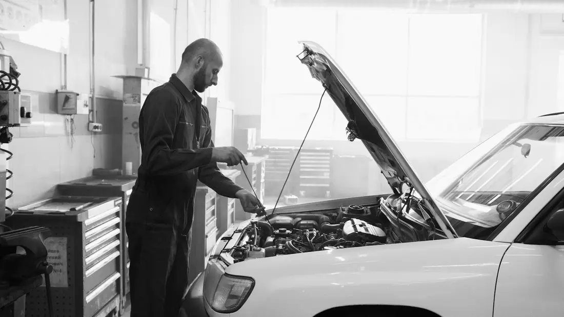 An Apex Auto Works technician working under the hood of a vehicle