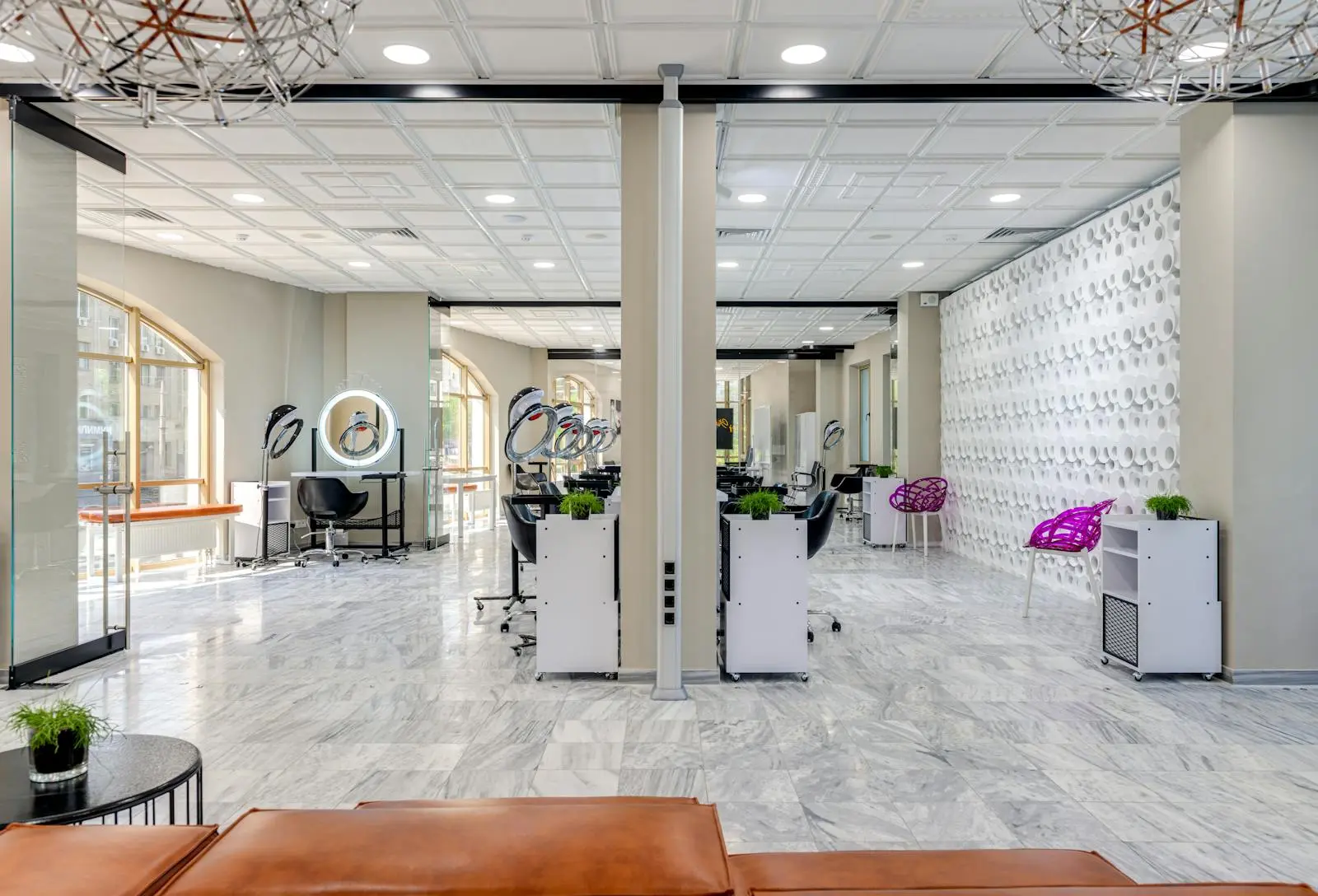 The bright, elegant interior of Lumière Salon with marble floors and styling stations