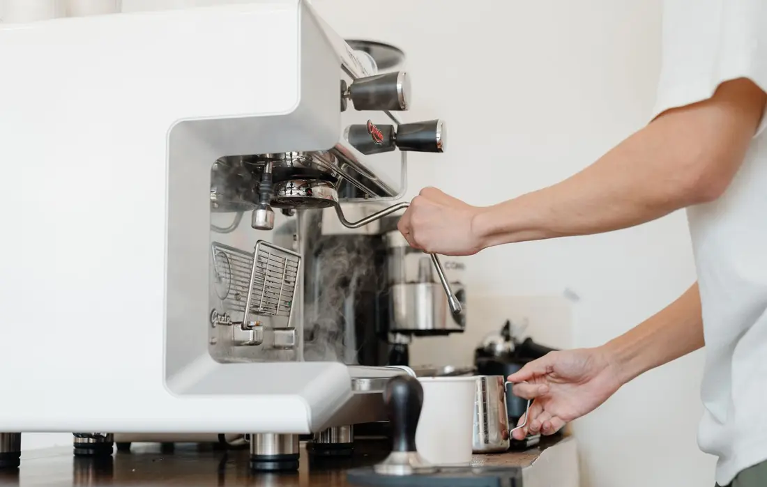 A barista pulling a shot on the espresso machine at River Bend Café