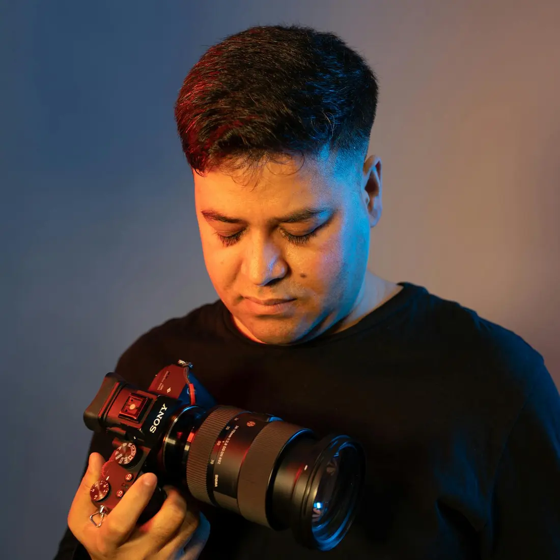 Noah Vance, founder of Studio Noir, holding a camera in dramatic studio light